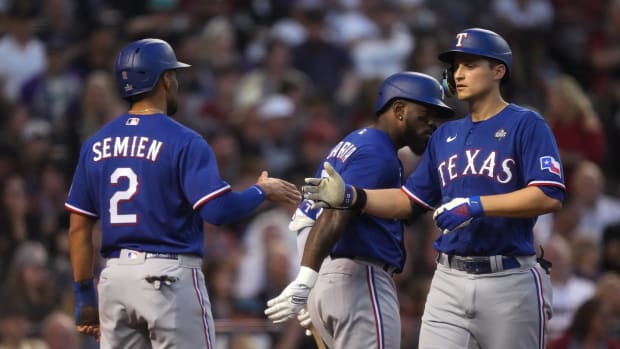 Texas Rangers shortstop Corey Seager (right) is congratulated by second baseman Marcus Semien (2) after hitting a two-run home run against the Arizona Diamondbacks during the third inning in game three of the 2023 World Series at Chase Field on Oct. 30, 2023, in Phoenix, Arizona.
