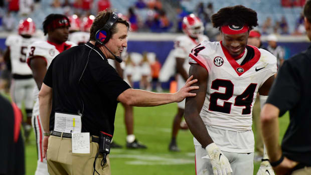 Georgia Bulldogs co-defensive coordinator and former Gator head coach Will Muschamp shares a smile with Georgia Bulldogs defensive back Malaki Starks (24) as the clock ticks down on Georgia's lopsided victory over the Gators at the annual Florida vs Georgia football game at EverBank Stadium in Jacksonville, FL, Saturday, October 27, 2023. Georgia walked away with a final score of 43 to 20. [Bob Self/Florida Times-Union]