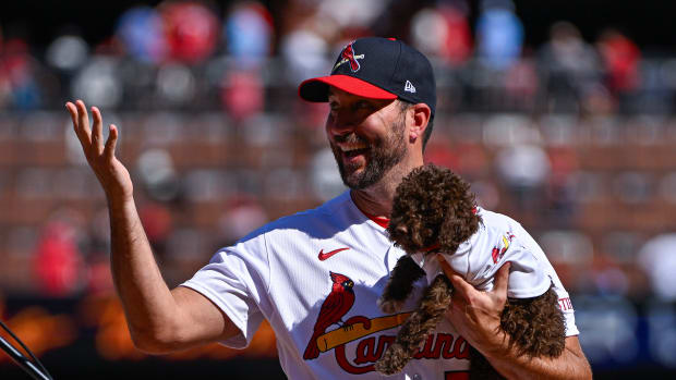Cardinals pitcher Adam Wainwright holding a puppy at a ceremony given in his honor before St. Louis's 4-3 win over the Reds on Oct. 1, 2023.