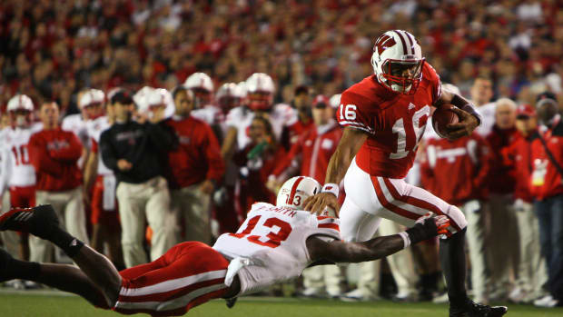 Oct 1, 2011; Madison, WI, USA; Wisconsin Badgers quarterback Russell Wilson (16) scores a touchdown as Nebraska Cornhuskers safety P.J. Smith (13) attempts a tackle during the third quarter at Camp Randall Stadium. Mandatory Credit: Brace Hemmelgarn-USA TODAY Sports