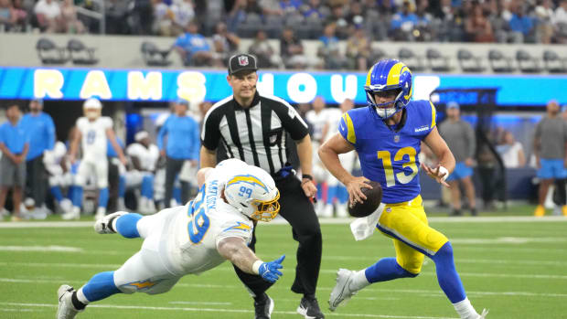 Aug 12, 2023; Inglewood, California, USA; Los Angeles Rams quarterback Stetson Bennett (13) is pursued by Los Angeles Chargers defensive tackle Scott Matlock (99) in the first half at SoFi Stadium. (Kirby Lee / USA TODAY Sports).
