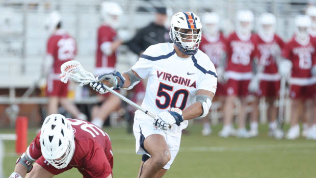 UVA midfielder Ricky Miezan cradles the ball during the Virginia men's lacrosse game against Harvard at Klockner Stadium.