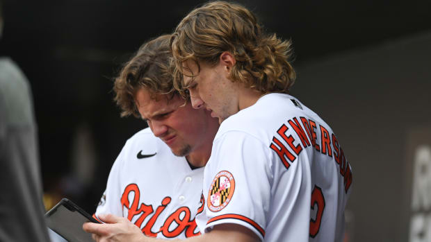 Sep 4, 2022; Baltimore, Maryland, USA; Baltimore Orioles catcher Adley Rutschman (left) looks at a tablet withsecond baseman Gunnar Henderson (2) in the dugout during the game against the Oakland Athletics at Oriole Park at Camden Yards. Mandatory Credit: Tommy Gilligan-USA TODAY Sports