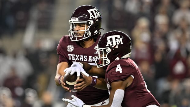 Nov 11, 2023; College Station, Texas, USA; Texas A&M Aggies quarterback Jaylen Henderson (16) hands off the ball to running back Amari Daniels (4) during the first quarter at Kyle Field.
