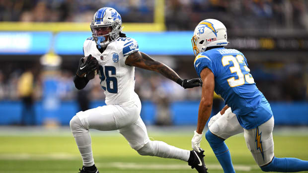 Detroit Lions running back Jahmyr Gibbs (26) runs the ball while defended by Los Angeles Chargers cornerback Deane Leonard (33) during the first half at SoFi Stadium.