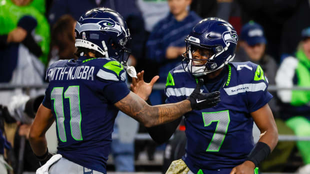 Seattle Seahawks quarterback Geno Smith (7) celebrates with wide receiver Jaxon Smith-Njigba (11) after throwing a touchdown pass against the Washington Commanders during the fourth quarter at Lumen Field.