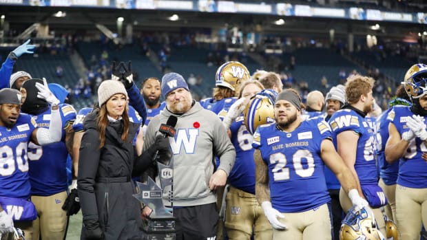 Nov 11, 2023; Winnipeg, Manitoba, CAN; Winnipeg Blue Bombers head coach Mike O'Shea and running back Brady Oliveira (20) receive the Western Division trophy after the game against the BC Lions at IG Field. Winnipeg wins 24-13 to advance to 2023 Grey Cup. Mandatory Credit: Bruce Fedyck-USA TODAY Sports.