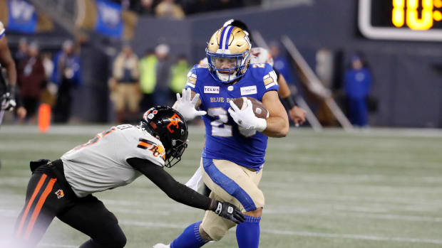 Nov 11, 2023; Winnipeg, Manitoba, CAN; Winnipeg Blue Bombers running back Brady Oliveira (20) breaks a tackle by BC Lions defensive back T.J. Lee (6) during the first half of the game at IG Field. Mandatory Credit: Bruce Fedyck-USA TODAY Sports