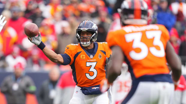 Denver Broncos quarterback Russell Wilson (3) passes to running back Javonte Williams (33) for a touchdown against the Kansas City Chiefs in the first quarter at Empower Field at Mile High.
