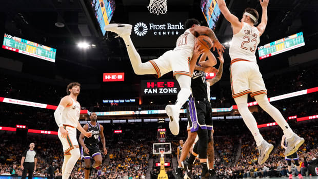 Nov 17, 2023; San Antonio, Texas, USA; Sacramento Kings center Domantas Sabonis (10) gets crushed by San Antonio Spurs forward Julian Champagnie (30) and center Zach Collins (23) during the second half at Frost Bank Center.
