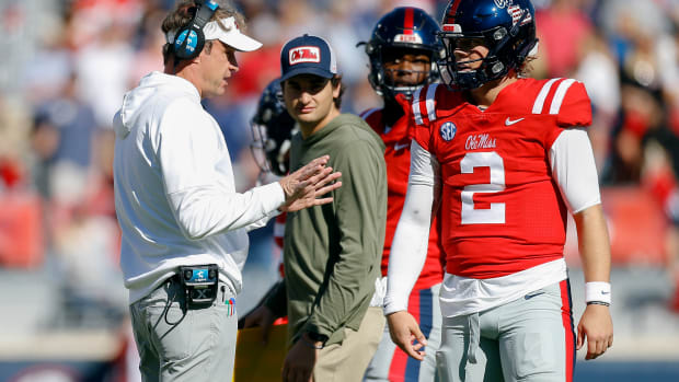Nov 18, 2023; Oxford, Mississippi, USA; Mississippi Rebels head coach Lane Kiffin (left) talks with Mississippi Rebels quarterback Jaxson Dart (2) during a time out during the first half against the Louisiana Monroe Warhawks at Vaught-Hemingway Stadium. Mandatory Credit: Petre Thomas-USA TODAY Sports  