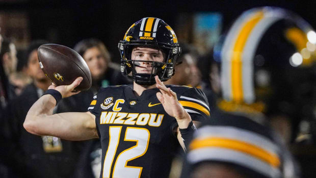 Missouri Tigers quarterback Brady Cook (12) warms up against the Florida Gators prior to a game at Faurot Field at Memorial Stadium.