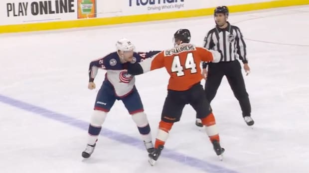 Flyers’ Nicolas Deslauriers and Blue Jackets’ Mathieu Olivier fight at center ice.