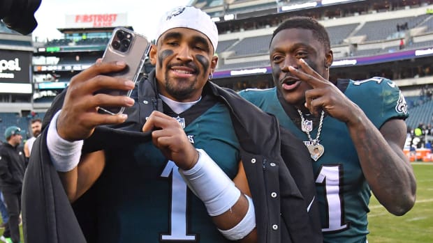 Jalen Hurts and A.J. Brown take a selfie on the field after a game.