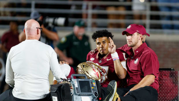 Nov 18, 2023; Tallahassee, Florida, USA; Florida State Seminoles quarterback Jordan Travis (13) waves to fans while being carted off after an injury against the North Alabama Lions during the first quarter at Doak S. Campbell Stadium.