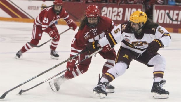 Wisconsin's Kirsten Simms (27) control the puck as Minnesota's Madeline Wethington defends during the teams' national semifinals at AMSOIL Arena in Duluth, Minn. on Friday March 17, 2023. Uw Minnesota Frozen Four 4 March 17 2023