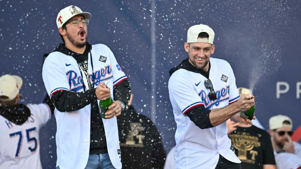 Rangers pitcher Dane Dunning, left and pitcher Nathan Eovaldi spray the crowd with champagne during the 2023 World Series champion celebration