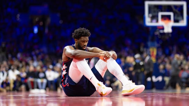 Nov 21, 2023; Philadelphia, Pennsylvania, USA; Philadelphia 76ers center Joel Embiid (21) sits on the court after a play in which he was fouled during the third quarter against the Cleveland Cavaliers at Wells Fargo Center.