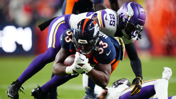 Minnesota Vikings safety Theo Jackson (25) tackles Denver Broncos running back Javonte Williams (33) in the fourth quarter at Empower Field at Mile High.