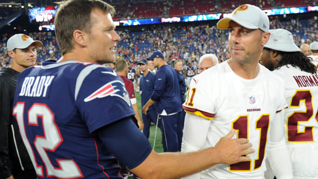 Patriots quarterback Tom Brady (12) greets Washington quarterback Alex Smith (11) after the game at Gillette Stadium.