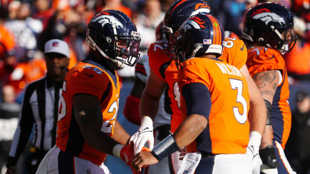 Denver Broncos running back Samaje Perine (25) celebrates his touchdown with quarterback Russell Wilson (3) and tight end Adam Trautman (82) in the first quarter against the Cleveland Browns at Empower Field at Mile High.