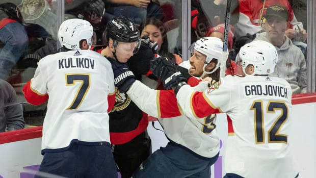Ottawa Senators’ Brady Tkachuk shoves three Florida Panthers players.