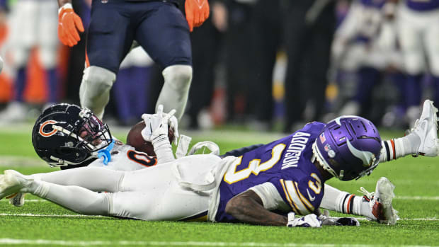 Nov 27, 2023; Minneapolis, Minnesota, USA; Chicago Bears safety Jaquan Brisker (9) catches an interception off Minnesota Vikings quarterback Joshua Dobbs (not pictured) as wide receiver Jordan Addison (3) lays on the field during the second quarter at U.S. Bank Stadium.