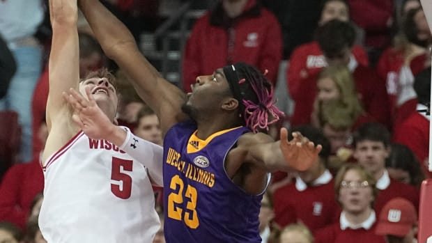 Wisconsin forward Tyler Wahl (5) scores on Western Illinois center Drew Cisse (23) during the first half of their game Monday, November 27, 2023 at the Kohl Center in Madison, Wisconsin.
