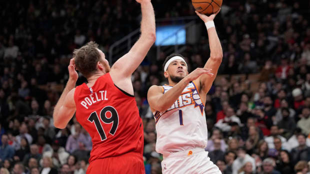Phoenix Suns guard Devin Booker (1) goes up to make a basket as Toronto Raptors center Jakob Poeltl (19) defends during the first half at Scotiabank Arena.