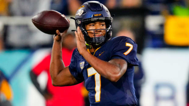 Toledo Rockets quarterback Dequan Finn attempts a pass during a college football game in the MAC.