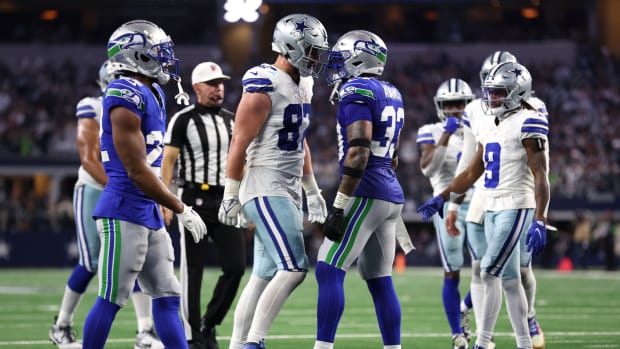 Nov 30, 2023; Arlington, Texas, USA; Dallas Cowboys tight end Jake Ferguson (87) and Seattle Seahawks safety Jamal Adams (33) talks after a play during the second half at AT&T Stadium.