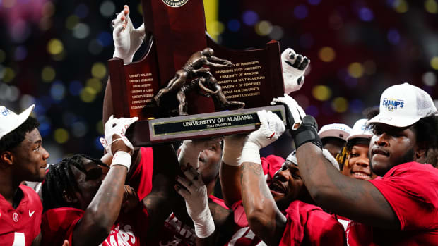 The Alabama Crimson Tide celebrate with the SEC championship trophy after defeating the Georgia Bulldogs at Mercedes-Benz Stadium.