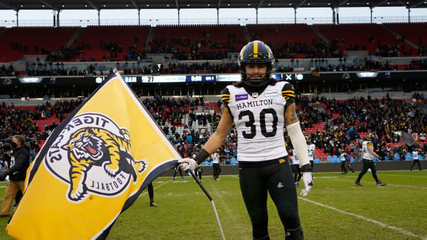 Dec 5, 2021; Toronto, Ontario, CAN; Hamilton Tiger-Cats defensive back Stavros Katsantonis (30) poses with a team flag on the field after a win over the Toronto Argonauts in the Canadian Football League Eastern Conference Final game at BMO Field. Mandatory Credit: John E. Sokolowski-USA TODAY Sports