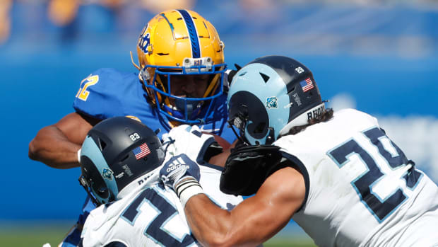 Sep 24, 2022; Pittsburgh, Pennsylvania, USA; Pittsburgh Panthers running back Vincent Davis (22) is tackled by Rhode Island Rams defensive back Jordan Jones (23) and safety Henry Yianakopolos (29) during the second quarter at Acrisure Stadium. Mandatory Credit: Charles LeClaire-USA TODAY Sports