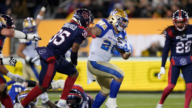 Nov 19, 2023; Hamilton, Ontario, CAN; Winnipeg Blue Bombers running back Brady Oliveira (20) runs past Montreal Alouettes defensive back Reggie Stubblefield (35) to score a touchdown during the first quarter of the 110th Grey Cup game at Tim Hortons Field. Mandatory Credit: John E. Sokolowski-USA TODAY Sports