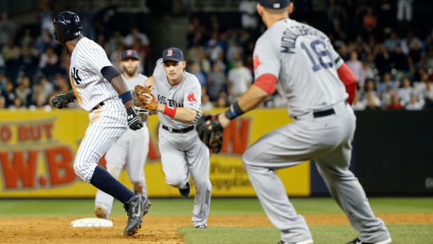 Sep 5, 2013; Bronx, NY, USA; New York Yankees left fielder Alfonso Soriano (12) is caught stealing third by Boston Red Sox shortstop Stephen Drew (7) during the ninth inning at Yankee Stadium. Boston won 9-8 in ten innings.