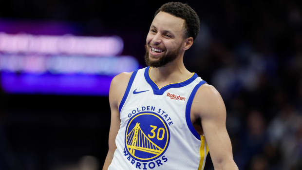 Warriors point guard Stephen Curry smiles while playing during a game.