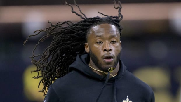 Saints running back Alvin Kamara jogs on a field while warming up before a game