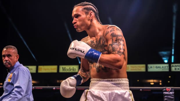 Regis Prograis holds his hands up in a boxing match with Jose Zepeda.