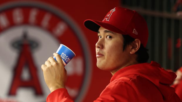 Angels star Shohei Ohtani looks to his left while in the dugout during a game.