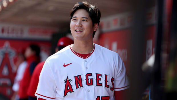 Angels designated hitter Shohei Ohtani smiles in the dugout.