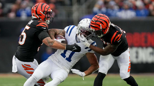 Cincinnati Bengals linebacker Logan Wilson (55) and Cincinnati Bengals safety Dax Hill (23) work to bring down Indianapolis Colts wide receiver Michael Pittman Jr. (11) on Sunday, Dec. 10, 2023, during a game against the Cincinnati Bengals at Paycor Stadium in Cincinnati.