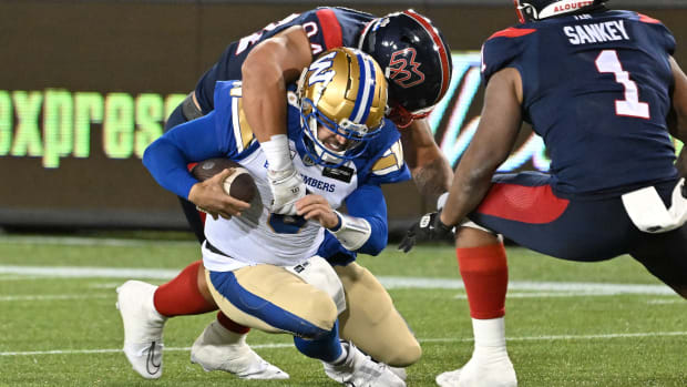 Nov 19, 2023; Hamilton, Ontario, CAN; Winnipeg Blue Bombers quarterback Zach Collaros (8) is tackled by Montreal Alouettes defensive lineman Mustafa Johnson (4) in the first half at Tim Hortons Field. Johnson was penalized for unnecessary roughness on the play. Mandatory Credit: Dan Hamilton-USA TODAY Sports  