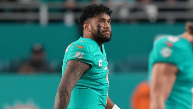 Dolphins quarterback Tua Tagovailoa walks off the field after getting sacked