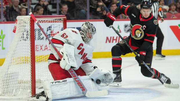 Carolina Hurricanes goalie Pyotr Kochetkov makes a save in front of Ottawa Senators left wing Brady Tkachuk.