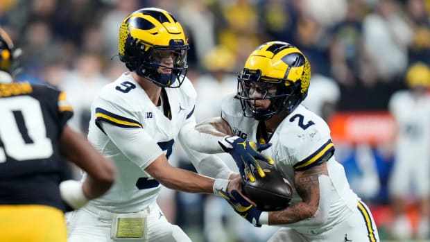 Michigan quarterback J.J. McCarthy, left, hands the ball off to running back Blake Corum.