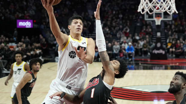 Dec 14, 2023; Portland, Oregon, USA; Utah Jazz forward Simone Fontecchio (16) shoots the ball against Portland Trail Blazers shooting guard Anfernee Simons (1) during the first half at Moda Center.