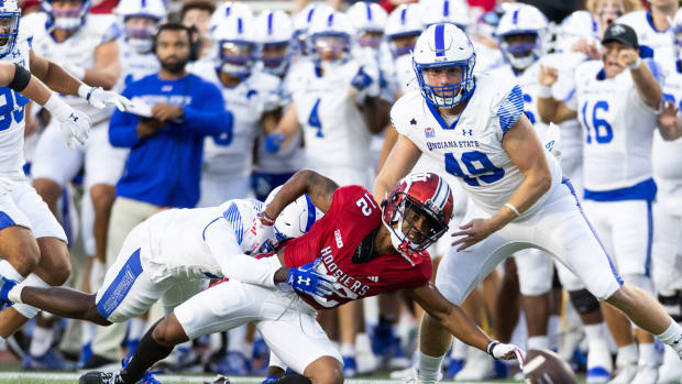 Sep 8, 2023; Bloomington, Indiana, USA; Indiana Hoosiers running back Jaylin Lucas (12) fumbles the ball while Indiana State Sycamores long snapper Jayden Perry (49) defends in the first half at Memorial Stadium. Mandatory Credit: Trevor Ruszkowski-USA TODAY Sports