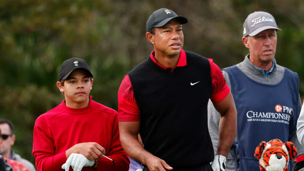 Dec 18, 2022; Orlando, Florida, USA; Caddy for Justin Thomas( not pictured) Jim Bones Mackay (right) looks on as Tiger Woods and son Charlie Woods (left) study their drive on the third tee during the final round of the PNC Championship golf tournament at Ritz Carlton Golf Club Grande Lakes Orlando Course. Mandatory Credit: Reinhold Matay-USA TODAY Sports