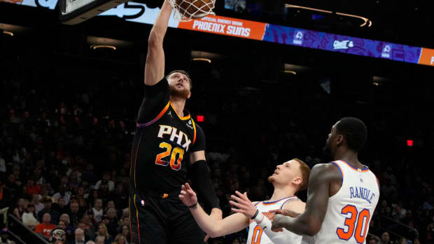 Phoenix Suns center Jusuf Nurkic (20) dunks over New York Knicks guard Donte DiVincenzo (0) and forward Julius Randle (30) in the first half at Footprint Center.